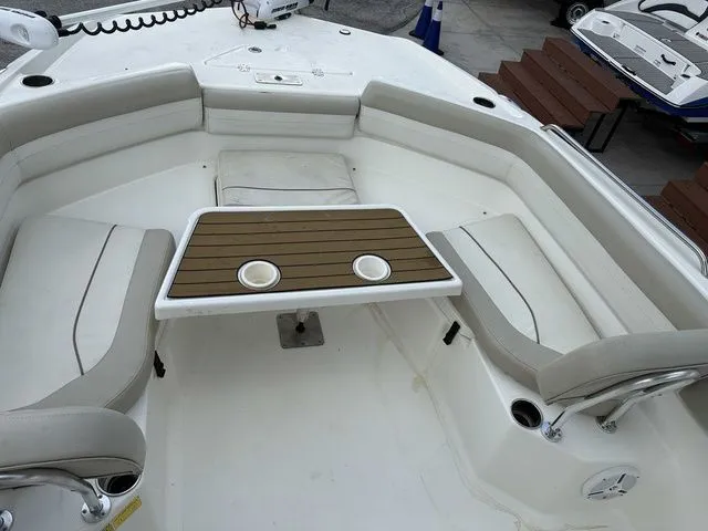 Slide: The Image of The image shows the seating area of a 2015 NauticStar 231 Coastal with a table in the center. - 8