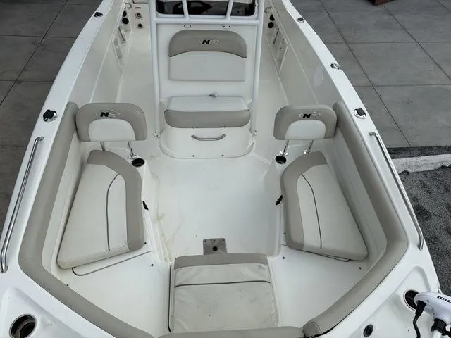 Slide: The Image of The image shows the cockpit of a 2015 NauticStar 231 Coastal with beige upholstery. - 7