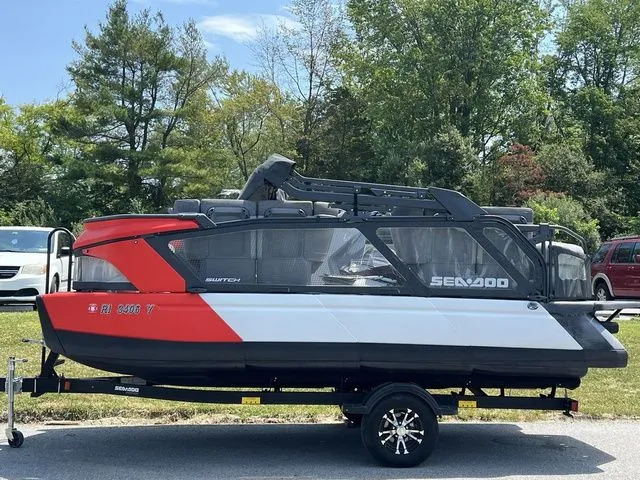 The Image of A 2022 Sea-Doo Switch Cruise 18 on a trailer, surrounded by trees. - 1