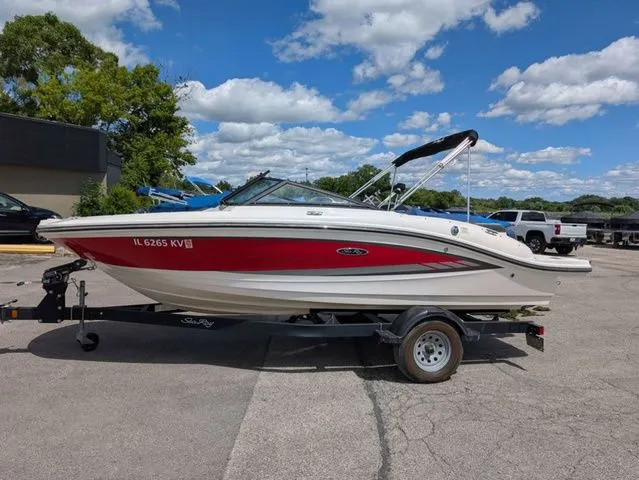 The Image of A red 2017 Sea Ray SPX 190 boat on a trailer in a parking lot. - 1