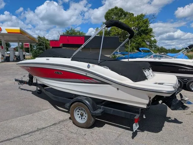 Slide: The Image of 2017 Sea Ray SPX 190 on a trailer, with red and white hull, parked outdoors. - 15