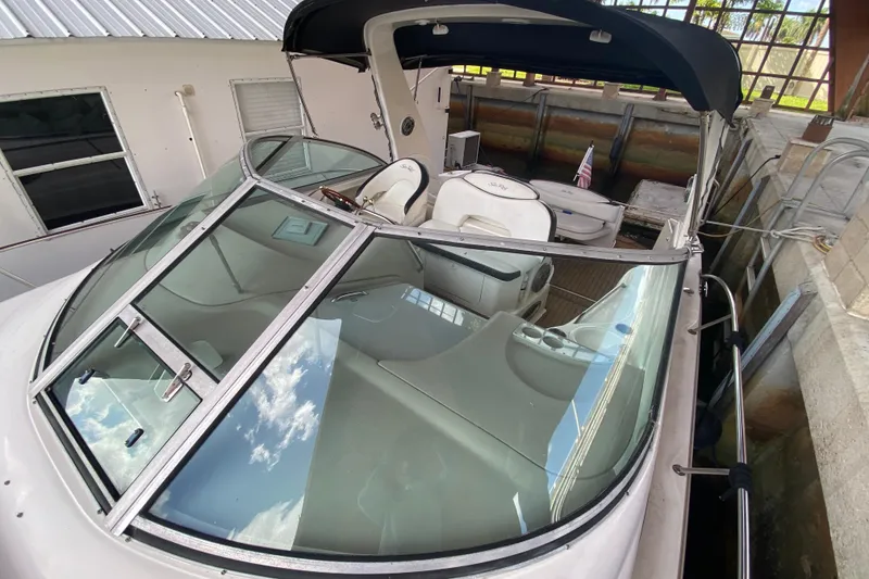 Slide: The Image of 2001 Sea Ray 340 Sundancer boat docked, featuring sleek design and spacious cockpit. - 12