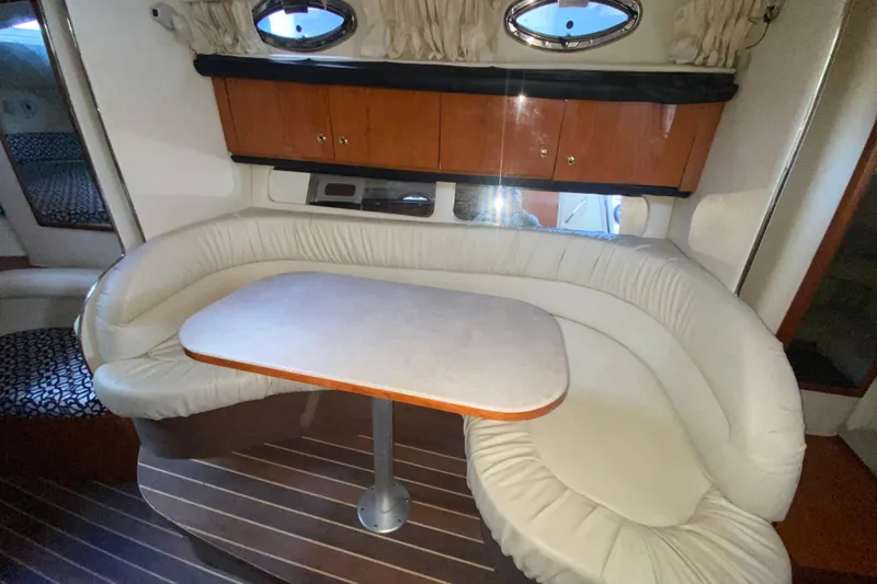 Slide: The Image of Interior of 2001 Sea Ray 340 Sundancer with curved seating and wooden cabinetry. - 31