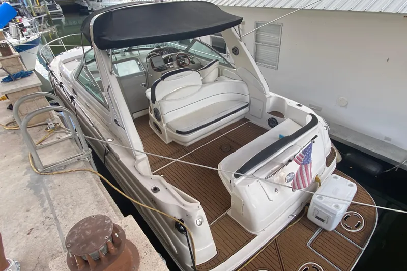 Slide: The Image of 2001 Sea Ray 340 Sundancer docked, featuring spacious deck and American flag. - 45