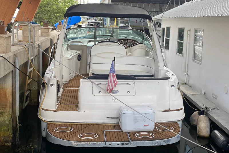 Slide: The Image of 2001 Sea Ray 340 Sundancer docked, featuring a spacious deck and American flag. - 43