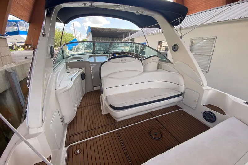 Slide: The Image of 2001 Sea Ray 340 Sundancer boat interior with white seating and wood flooring. - 16