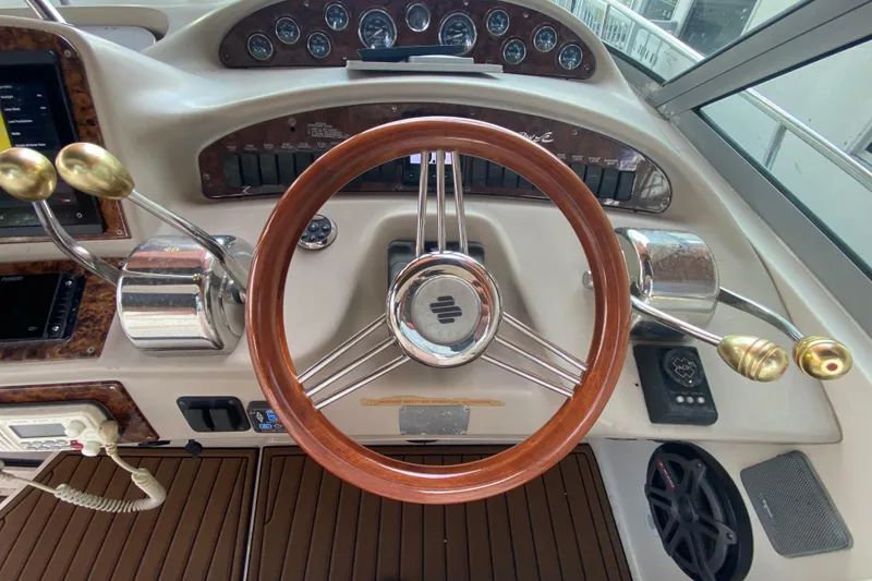 Slide: The Image of Steering wheel and controls of a 2001 Sea Ray 340 Sundancer boat. - 22