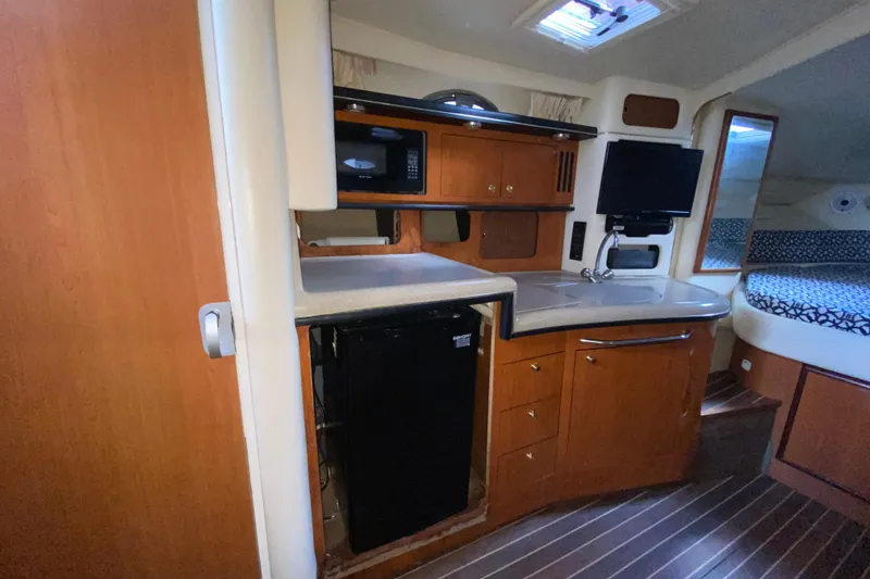 Slide: The Image of 2001 Sea Ray 340 Sundancer cabin interior with kitchenette, microwave, and compact fridge. - 32