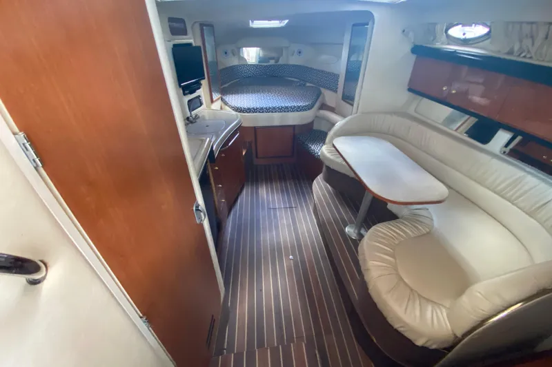 Slide: The Image of 2001 Sea Ray 340 Sundancer cabin interior with seating, table, and bed. - 28