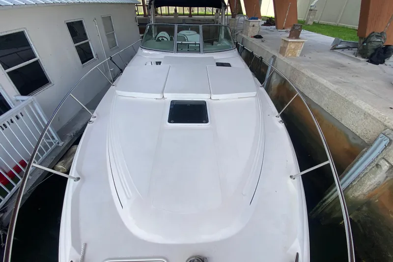 Slide: The Image of 2001 Sea Ray 340 Sundancer yacht docked, showcasing sleek white deck and railing. - 7