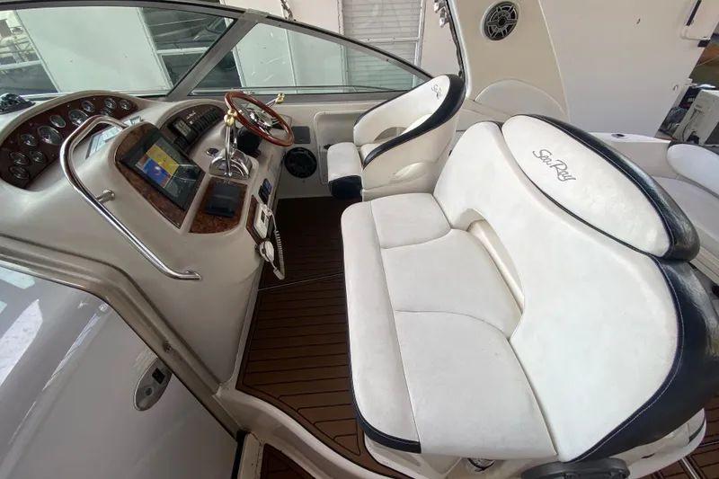 Slide: The Image of Cockpit of 2001 Sea Ray 340 Sundancer with white seating and wooden steering wheel. - 19