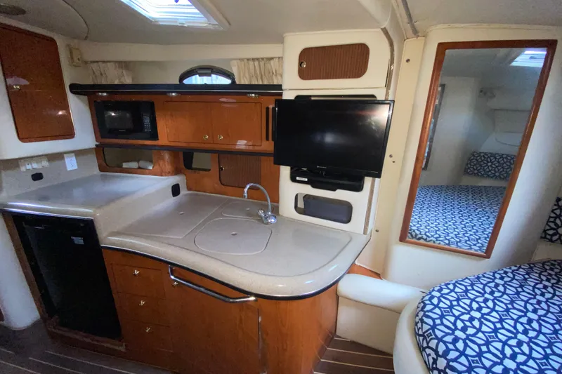 Slide: The Image of Interior of 2001 Sea Ray 340 Sundancer yacht with kitchenette and seating area. - 34