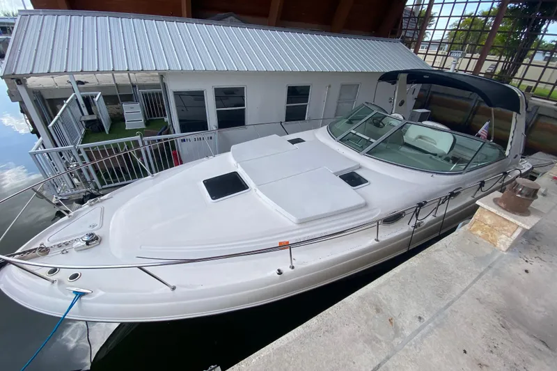 Slide: The Image of 2001 Sea Ray 340 Sundancer docked beside a modern boathouse. - 26