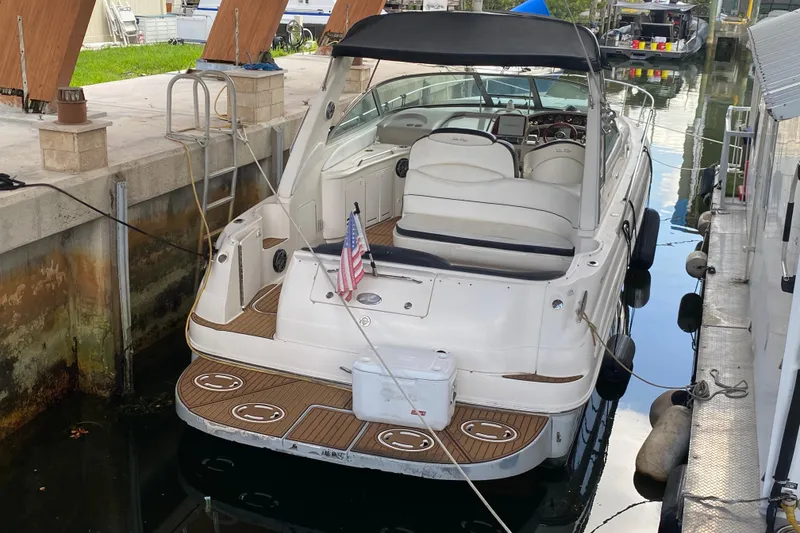 Slide: The Image of 2001 Sea Ray 340 Sundancer docked, featuring spacious seating and American flag. - 42