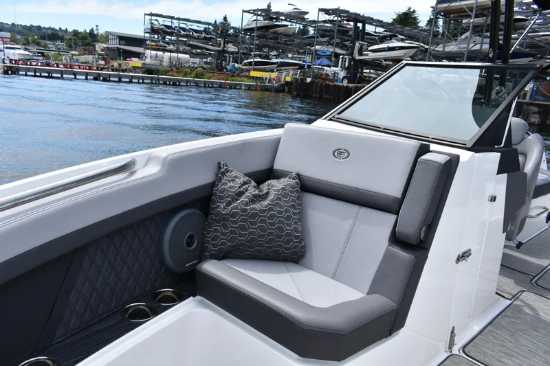 Slide: The Image of 2023 Cobalt R8 boat interior with gray seating, patterned pillow, and waterfront view. - 16