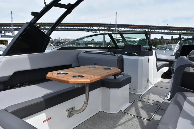 Slide: The Image of Interior of 2023 Cobalt R8 boat with seating and wooden table, under a bridge. - 22
