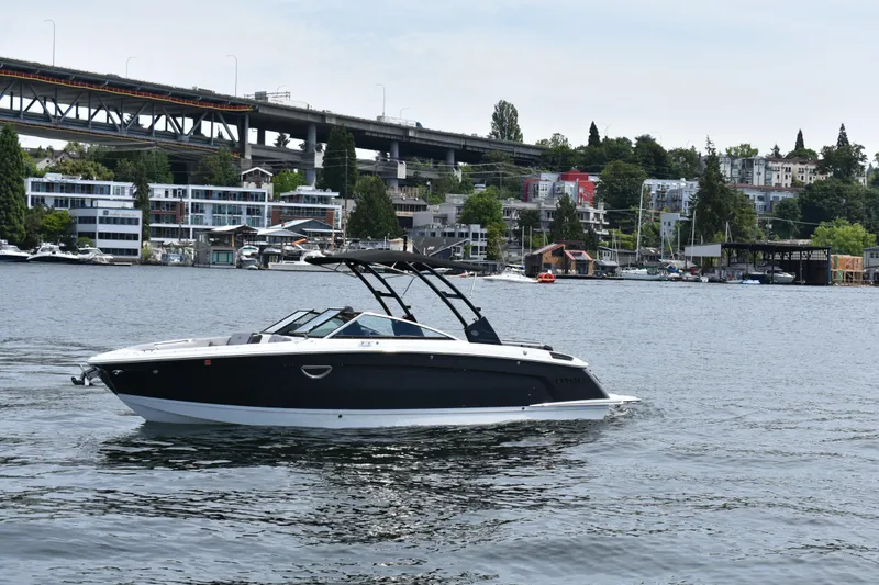 Slide: The Image of 2023 Cobalt R8 boat cruising on a scenic urban waterway with bridge and buildings. - 4