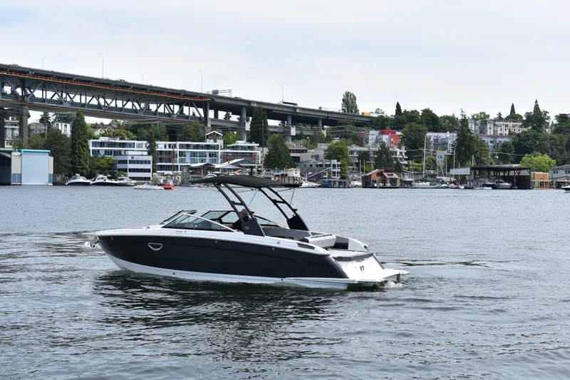 Slide: The Image of 2023 Cobalt R8 boat cruising on a scenic urban waterway with bridge and buildings. - 5