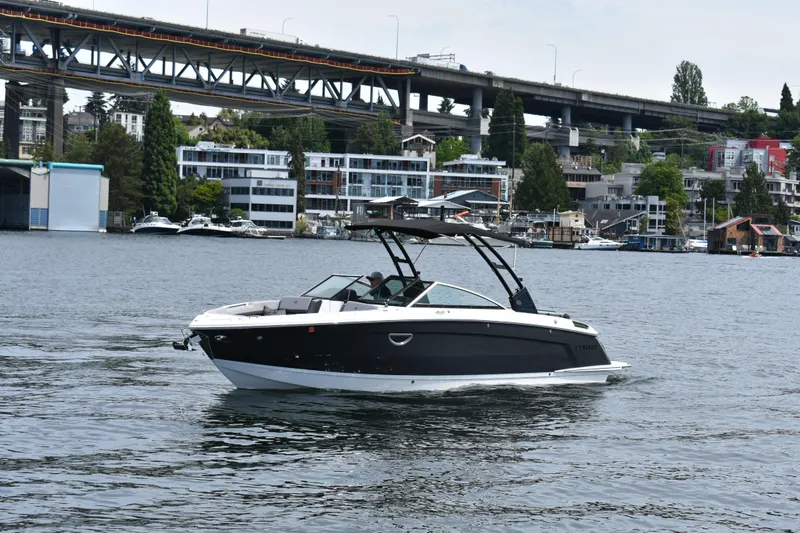 Slide: The Image of 2023 Cobalt R8 boat cruising on a scenic urban waterway with bridge and buildings. - 3