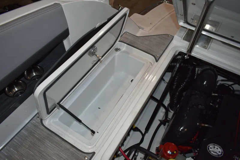 Slide: The Image of 2023 Cobalt R8 boat engine compartment with open storage hatch and visible engine components. - 32