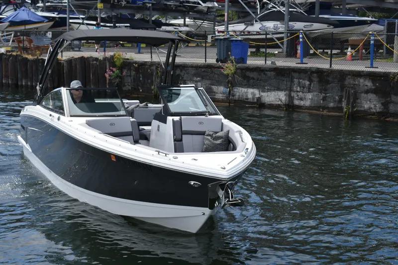 Slide: The Image of 2023 Cobalt R8 boat cruising near a dock, showcasing sleek design and luxury features. - 8