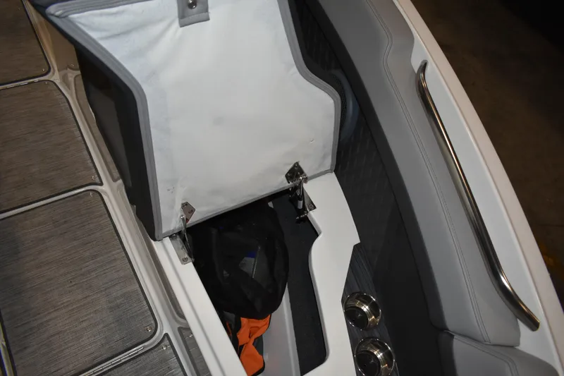 Slide: The Image of 2023 Cobalt R8 boat storage compartment with open lid and visible interior items. - 30