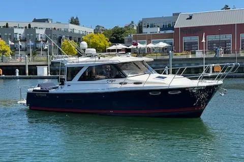 The Image of 2023 Cutwater C-30 Sedan boat docked in a marina with buildings in the background. - 0