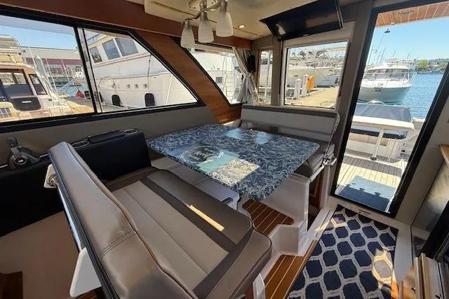 Slide: The Image of 2023 Cutwater C-30 Sedan interior with dining area, marina view, and modern design. - 18