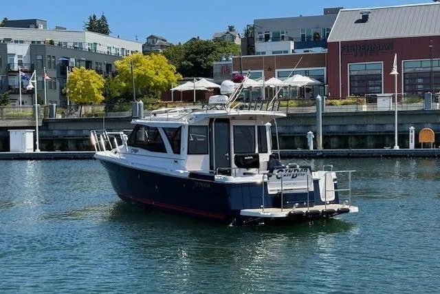 Slide: The Image of 2023 Cutwater C-30 Sedan boat docked in a marina with urban backdrop. - 6