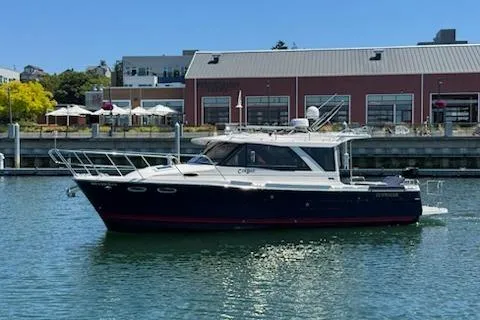 Slide: The Image of 2023 Cutwater C-30 Sedan boat docked in a marina with industrial buildings in the background. - 4