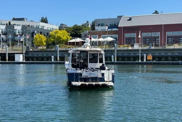 Slide: The Image of 2023 Cutwater C-30 Sedan boat cruising near a waterfront with buildings in the background. - 7
