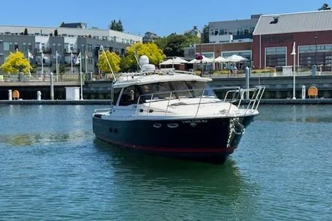 Slide: The Image of 2023 Cutwater C-30 Sedan boat docked in a marina with urban backdrop. - 2