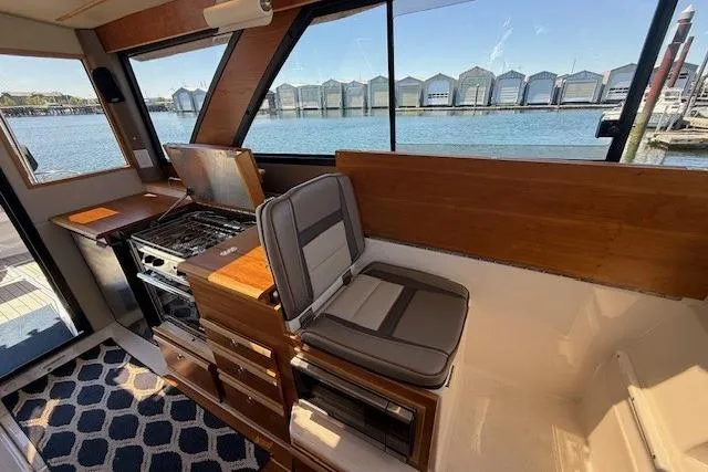 Slide: The Image of Interior of 2023 Cutwater C-30 Sedan boat with kitchen and seating area by the water. - 16