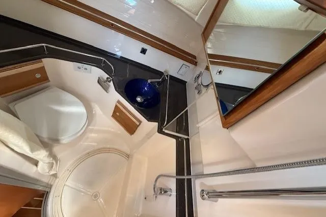 Slide: The Image of 2024 Cutwater C-30 Sedan bathroom with modern fixtures, blue sink, and shower. - 26