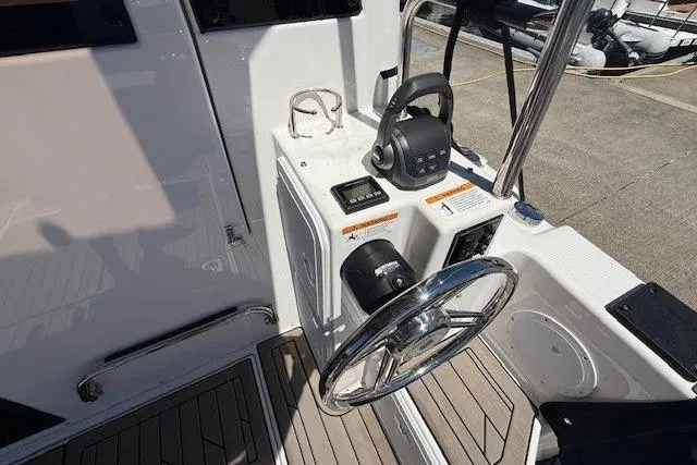 Slide: The Image of 2023 Cutwater C-30 Sedan helm with steering wheel and control panel, docked at marina. - 25