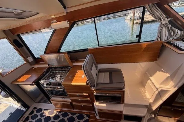 Slide: The Image of 2023 Cutwater C-30 Sedan interior with kitchen, seating, and waterfront view. - 15