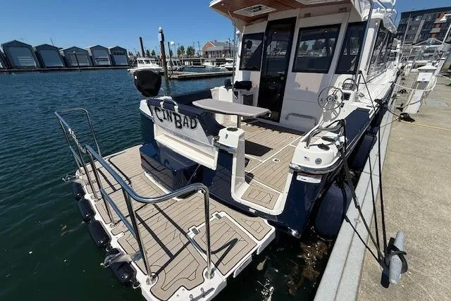 Slide: The Image of 2023 Cutwater C-30 Sedan docked, showcasing rear deck and seating area. - 11