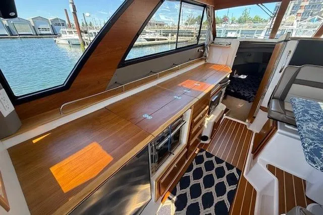 Slide: The Image of Interior of 2023 Cutwater C-30 Sedan yacht with wood finishes and marina view. - 14
