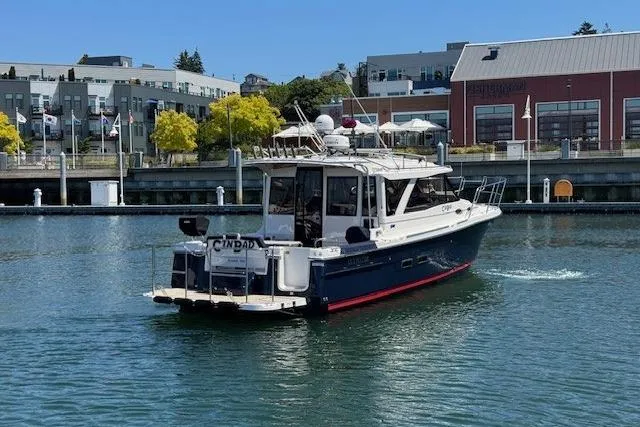 Slide: The Image of 2023 Cutwater C-30 Sedan boat cruising in a marina with modern buildings in the background. - 8