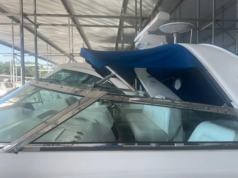 Slide: The Image of A 1997 Sea Ray Sundancer 370 with a blue sunshade docked in a marina. - 7