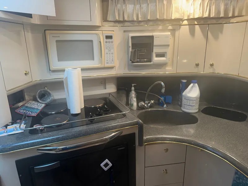 Slide: The Image of The galley of a 1997 Sea Ray Sundancer 370 with a microwave, stove, and sink. - 11