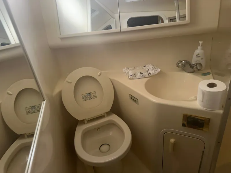 Slide: The Image of The image shows a boat bathroom with a toilet, sink, and mirror. - 16