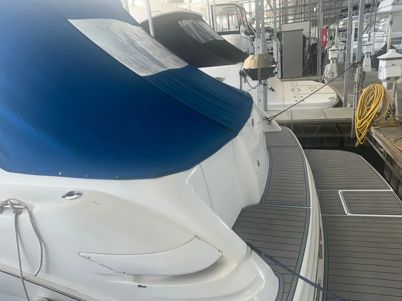 Slide: The Image of A 1997 Sea Ray Sundancer 370 docked in a covered marina. It features a blue canopy. - 8