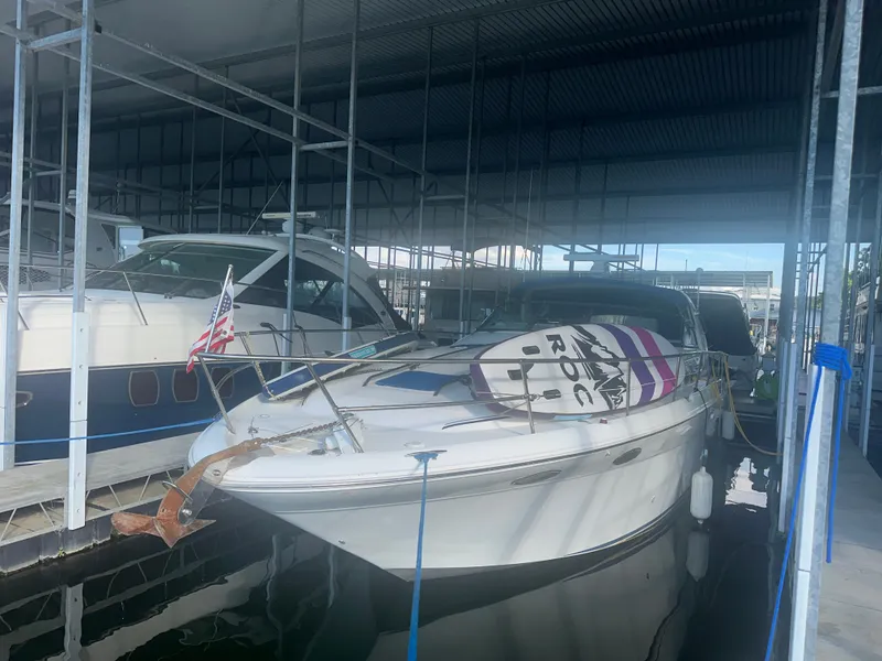 Slide: The Image of A 1997 Sea Ray Sundancer 370 is docked under a covered area. A paddleboard is on the deck. - 5