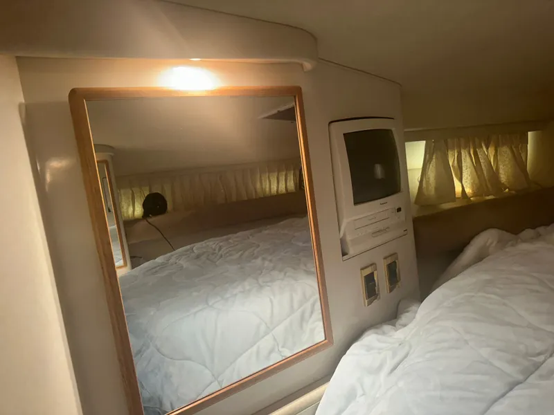 Slide: The Image of Interior of a 1997 Sea Ray Sundancer 370 with bed, mirror, and TV. - 19
