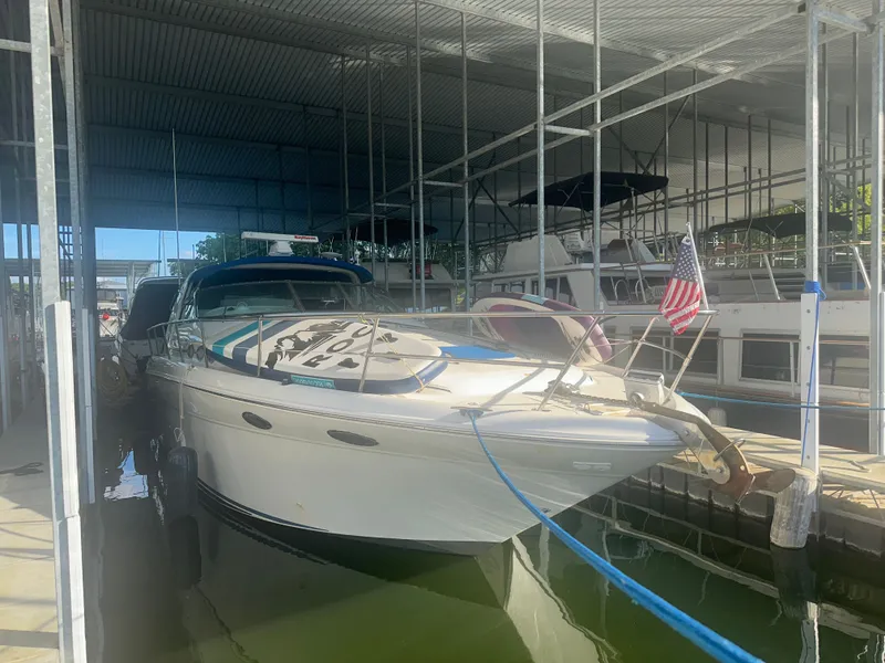 Slide: The Image of A 1997 Sea Ray Sundancer 370 is docked under a covered area. An American flag flies at the bow. - 4