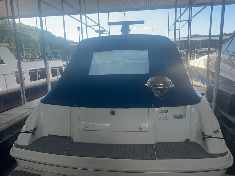 Slide: The Image of The image shows the stern of a 1997 Sea Ray Sundancer 370 in a covered dock. - 1