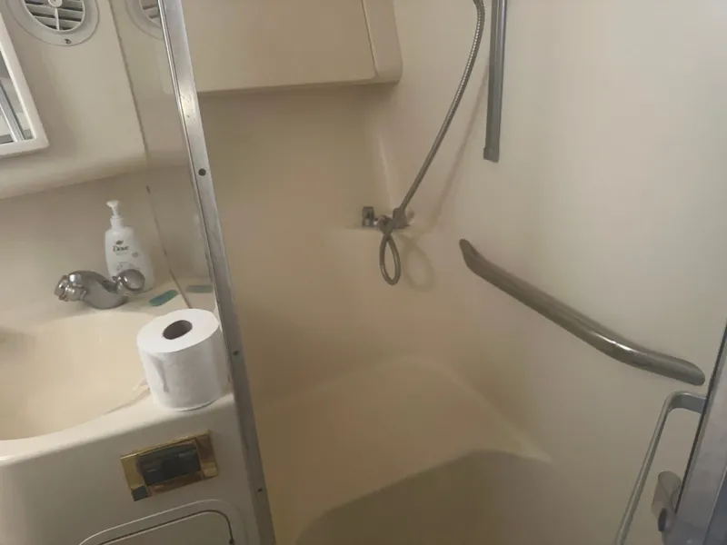 Slide: The Image of The image shows a boat bathroom with a shower, sink, and handrail. - 15