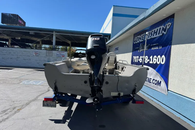 Slide: The Image of 2008 Crestliner 1750 Fish Hawk SC boat with outboard motor, parked near a fishing store. - 6