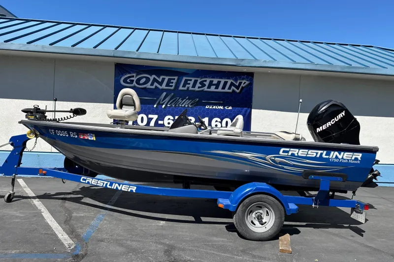 The Image of 2008 Crestliner 1750 Fish Hawk SC boat on trailer, parked outside marine shop. - 1